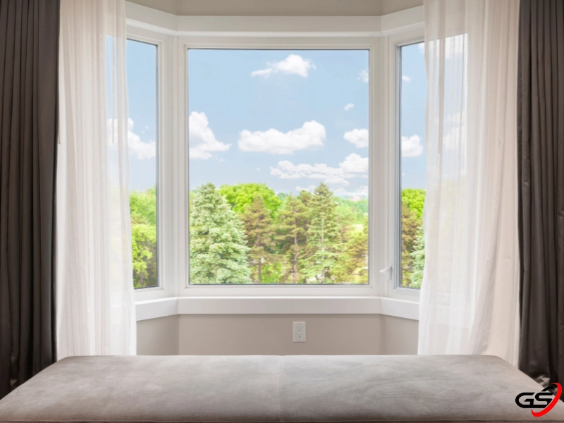 Triple pane windows in a modern home overlooking a view of the sky and trees. 