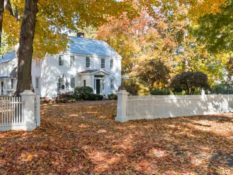 Historic home with white picket fence. Image serves as a complement to the blog "Replacing Historic Windows."