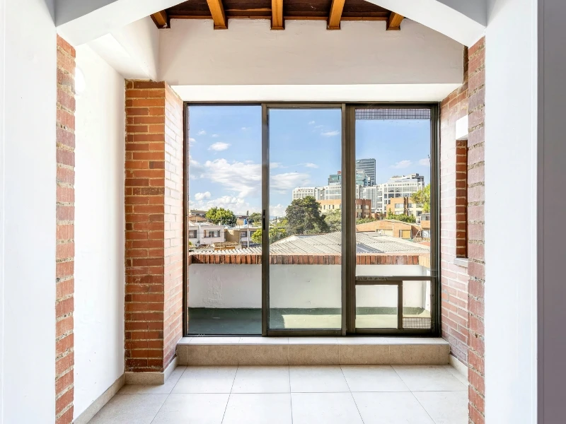 Glass door with a cityscape in the reflection, highlighting commercial glass contractor, Glass Solutions.