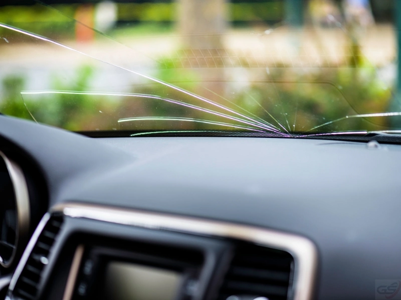 a Cracked windshield, highlighting the need for replacement and windshield camera calibration (ADAS).