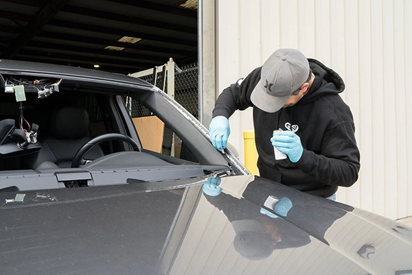 A certified technician fixing a car's windshield, highlighting windshield replacement Raleigh.